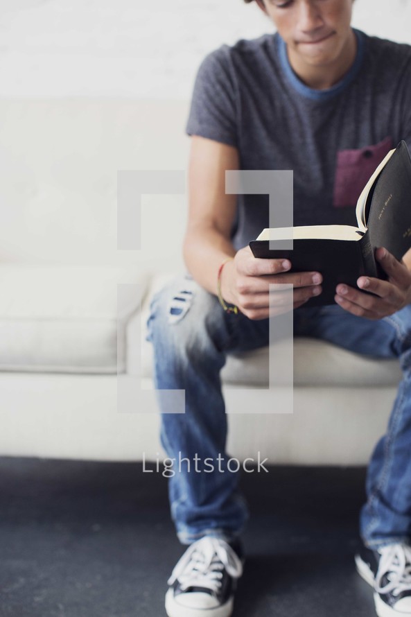 a teen boy reading a Bible 