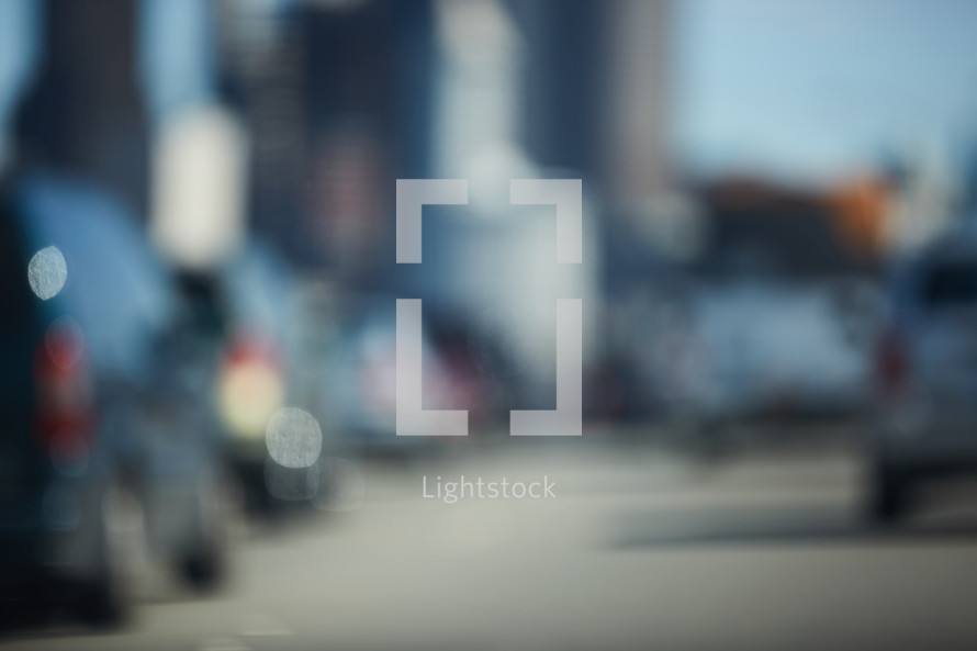 blurry image of cars in traffic in a city 