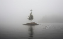 cross on a small island shrouded in fog.