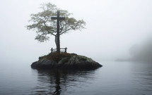 Cross on a small island shrouded in fog.