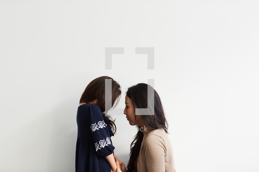 mother and daughter in studio praying