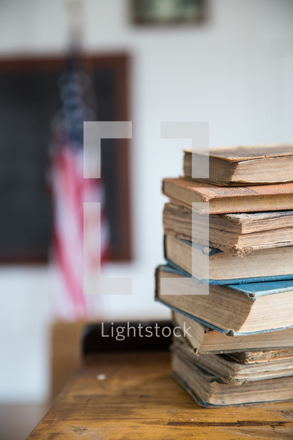 stack of school books on a desk 