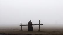 Monk prays in the foggy day