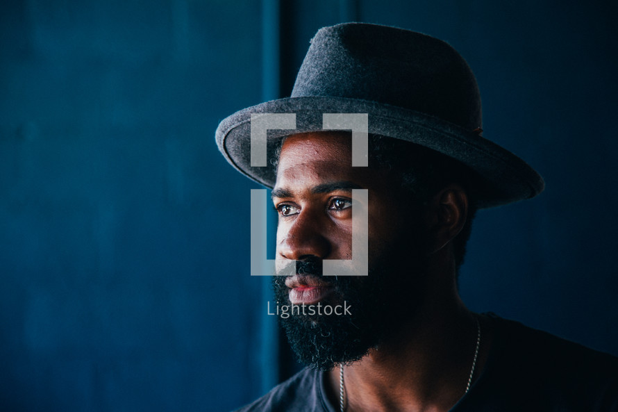 African American man with a thick beard wearing a hat 
