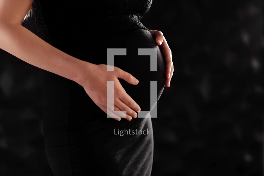 pregnant woman in a beautiful dress. Focus on the abdomen.