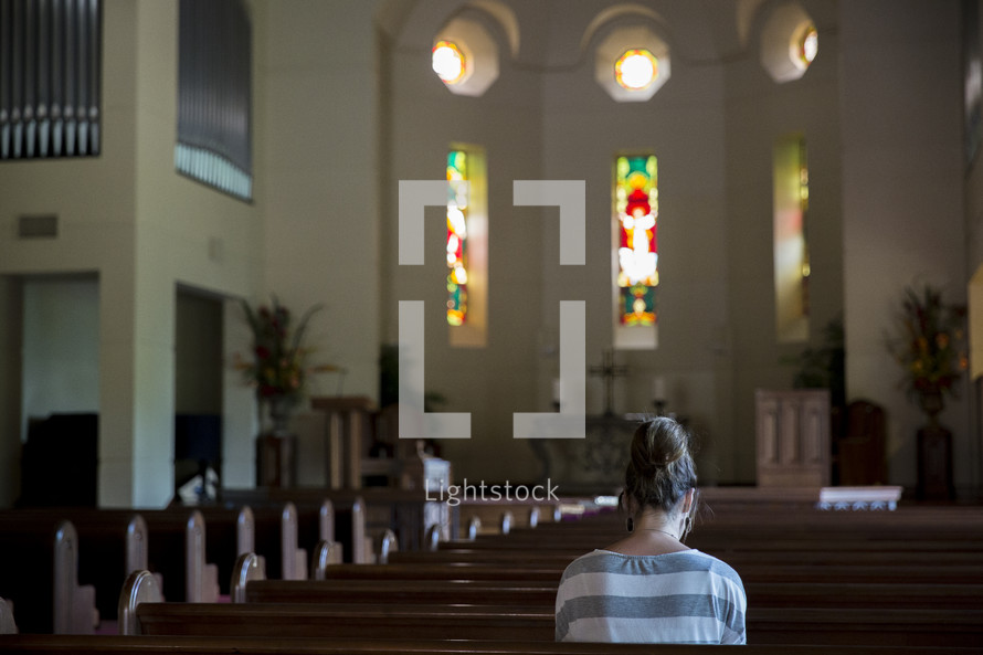 a woman praying in an empty church 