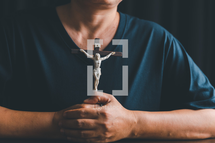 Asian person holding a crucifix