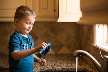 a boy washing dishes 