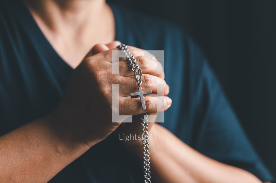 Silver cross necklace in hands