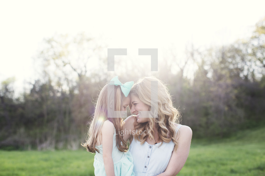  mother and daughter hugging outdoors 