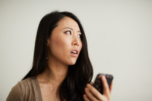 a woman reacting to something on her cellphone screen 