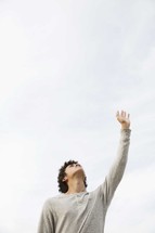 teen boy with his hand raised in praise 