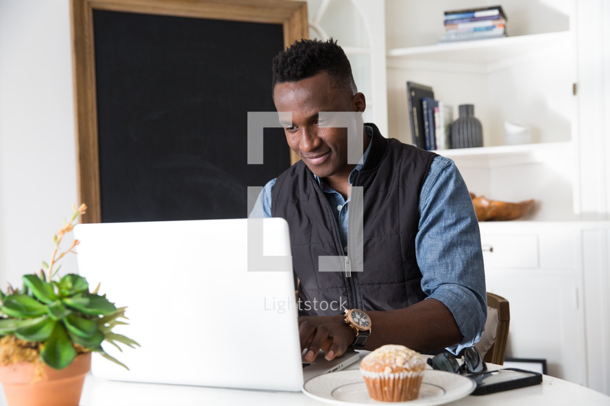 African American man working at a laptop computer 