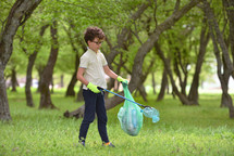 boy picking up trash outdoors 