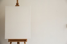 A blank canvas on a painter's easel.