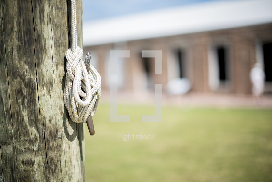 flag rope around a hook on a wooden post
