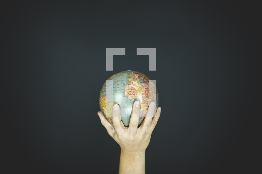 hand holding up a globe
