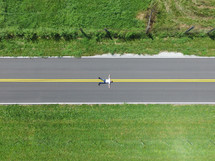 man lying in the middle of a road from overhead 