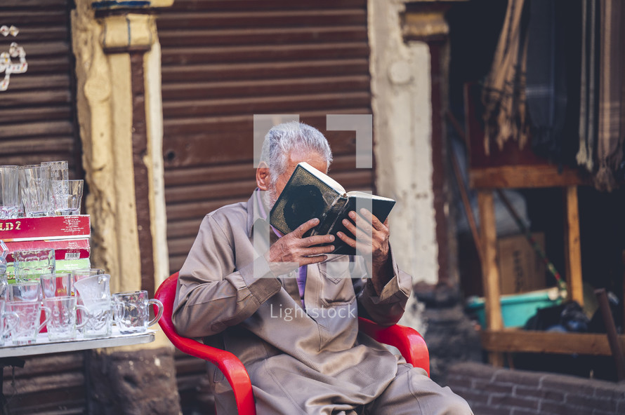 vendor reading a book at an outdoor market in Egypt 