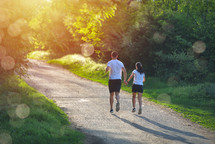 Young people jogging and exercising in nature, in morning sunrise warm light