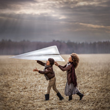 kids throwing a giant paper airplane 