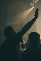 worshipers with hands raised during a worship service 