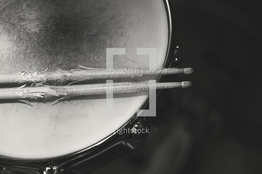a well used pair of drum sticks on drum
