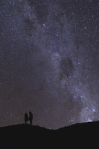 couple standing under stars in the night sky 