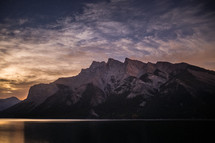 jagged mountain peaks and lake at sunset 