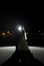 bride and groom dancing under a spotlight 