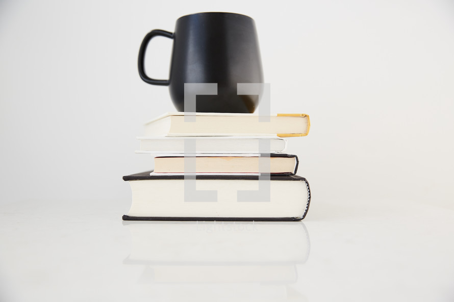 coffee mug on a stack of books 