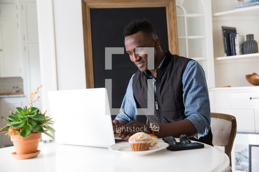 African American man sitting in front of a laptop computer 