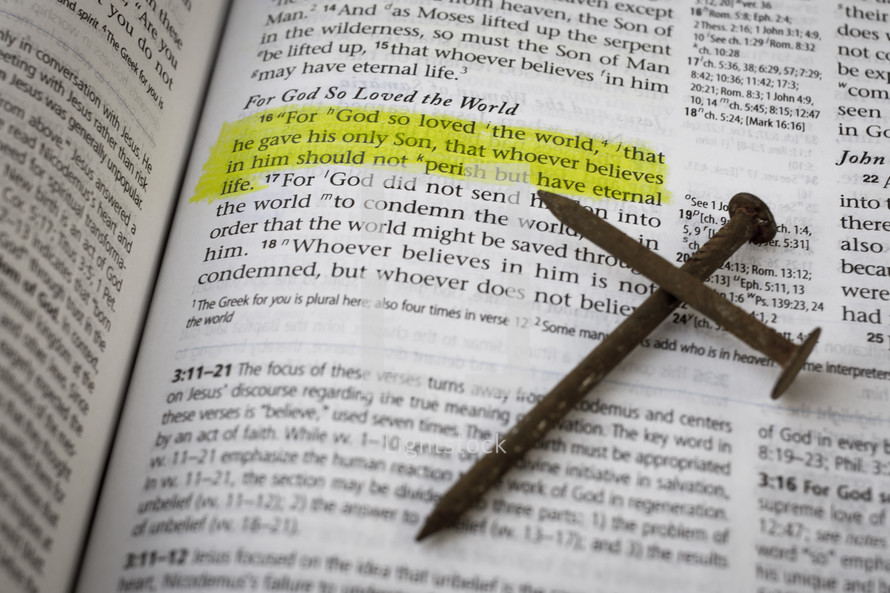 John 3:16 and a cross of nails on the pages of a Bible