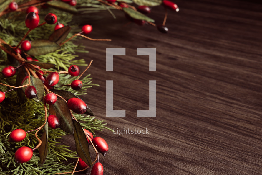 Christmas garland with berries and wood background