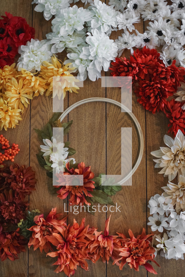 artificial fall flowers and wreath on a table