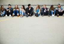 group of teens sitting on a parking deck