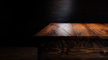 A beautiful walnut tabletop in a dark studio environment.