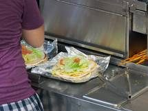 Street food vendor prepares a flat bread with salad and other ingredients. New York City, USA.