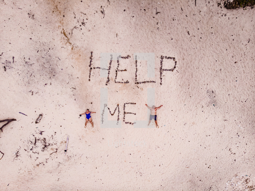 Help Me written in sand 