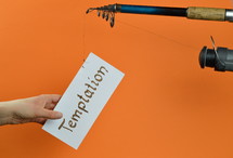 A fishing pole with a piece of paper with the word temptation on it 