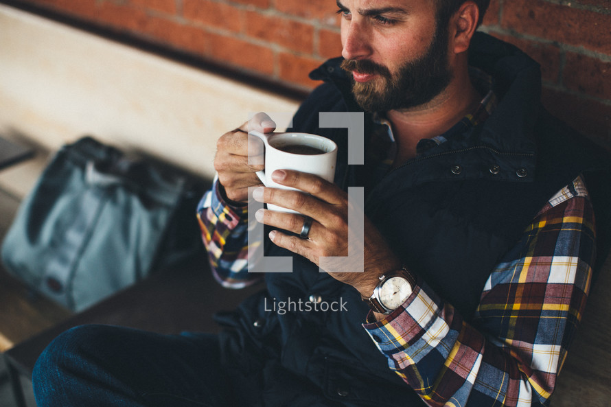 man sitting holding a cup of coffee 