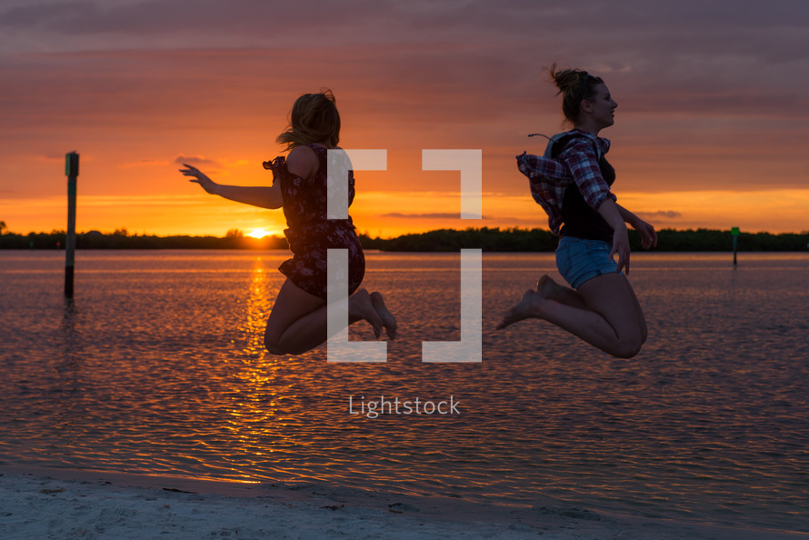 teen jumping on a beach at sunset 