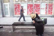 a woman waiting on a bench at a busstop 