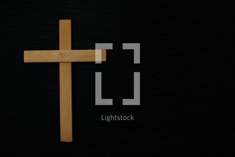 wood cross on black background 