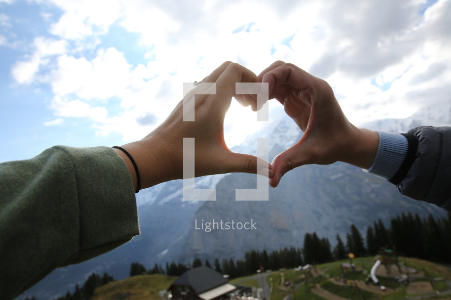 heart shape with hands and mountain 