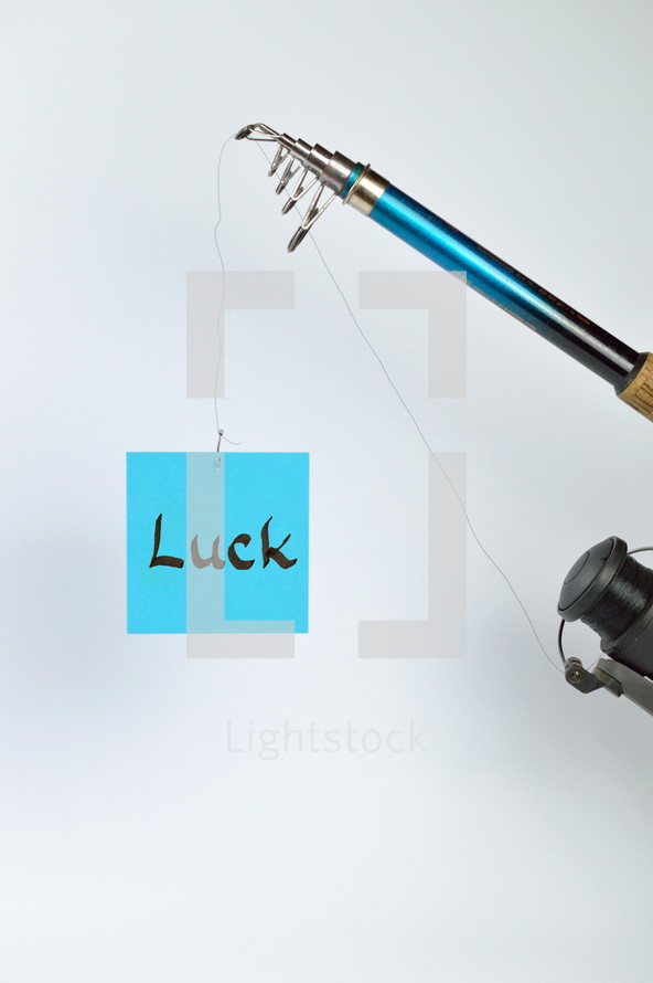 the word luck on a cyan piece of paper hanging from a fishing line 