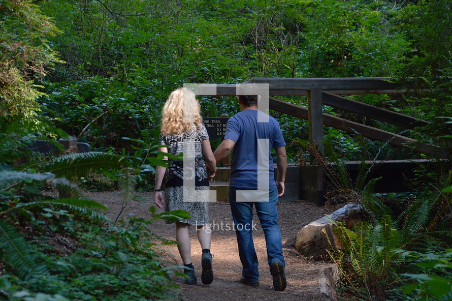 a couple walking on a path in a park - on the way as a couple