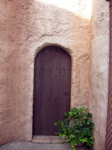 An arch shaped old wooden door like the kind you would see in the middle east during biblical times. 
