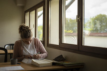 Woman studying in front of window