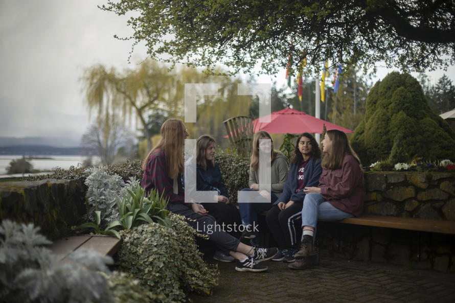 a group of young women sitting outdoors 